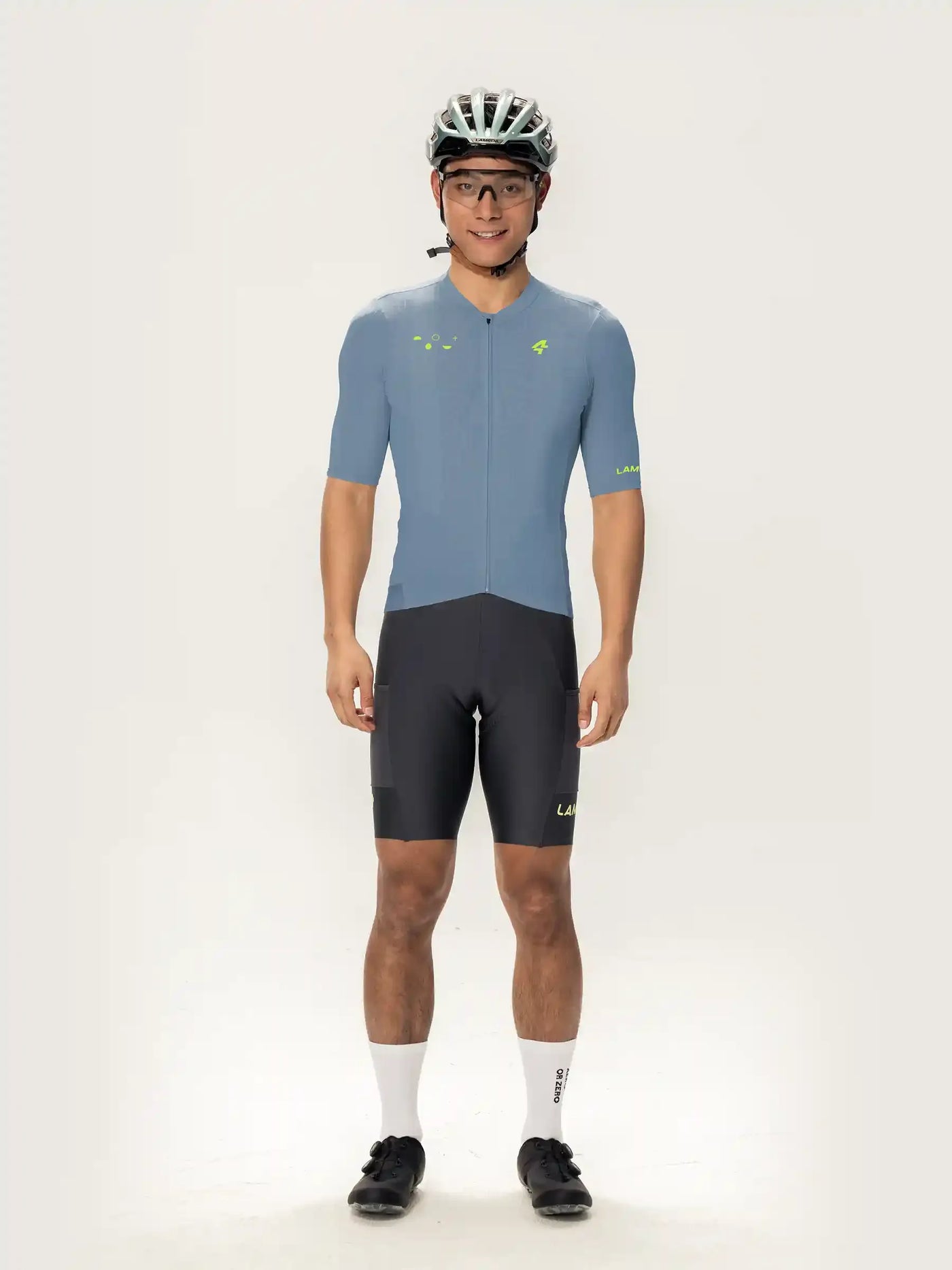 En man bär en blå roam kortärmad herrcykeltröja med neongröna detaljer och matchande shorts