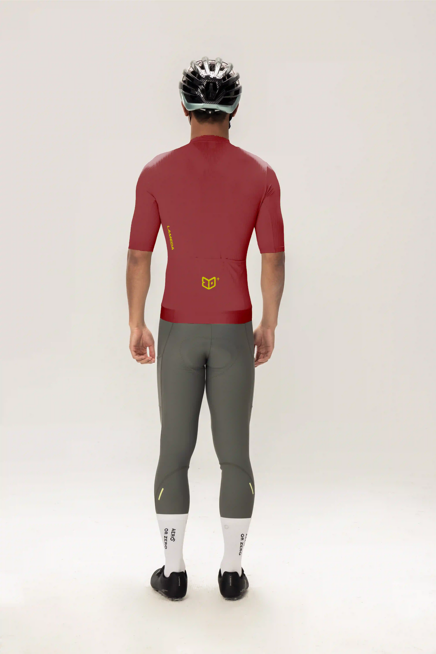Bakvy av roam kortärmad herrcykeltröja i lila på rött med gul logotyp kombinerad med grå cykelleggings