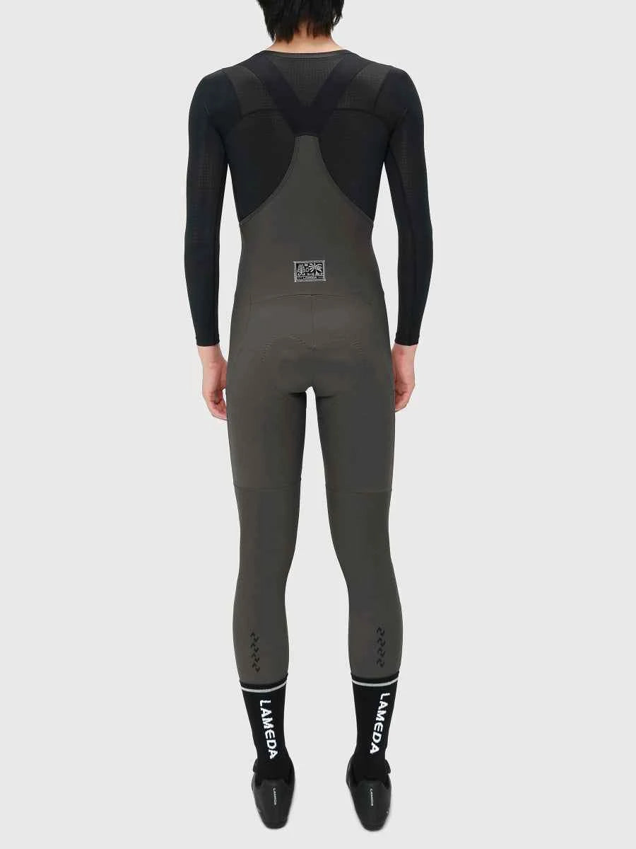 Back view of drift men’s thermal fleeced bib tights in black and dark gray laméda with mesh panels