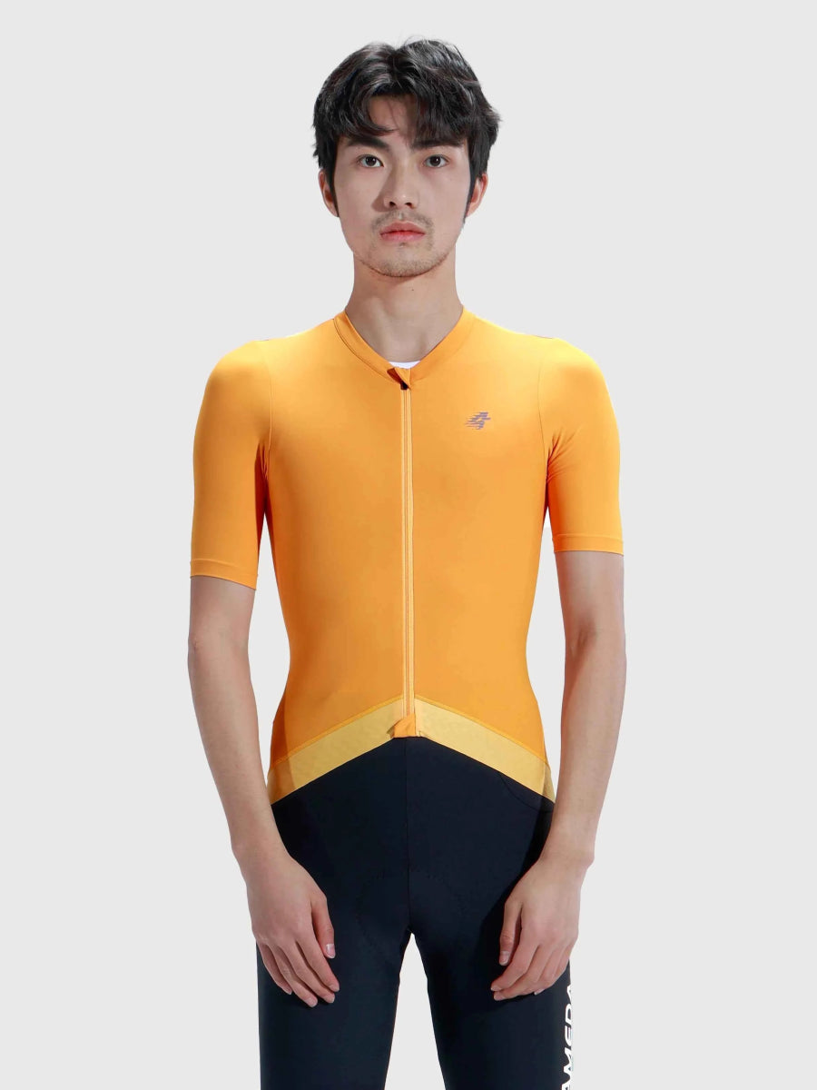 ljusorange LAMEDA flutter cykeltröja för män med gul gradientfärgad nederkant parat med svarta cykelshorts för cykling