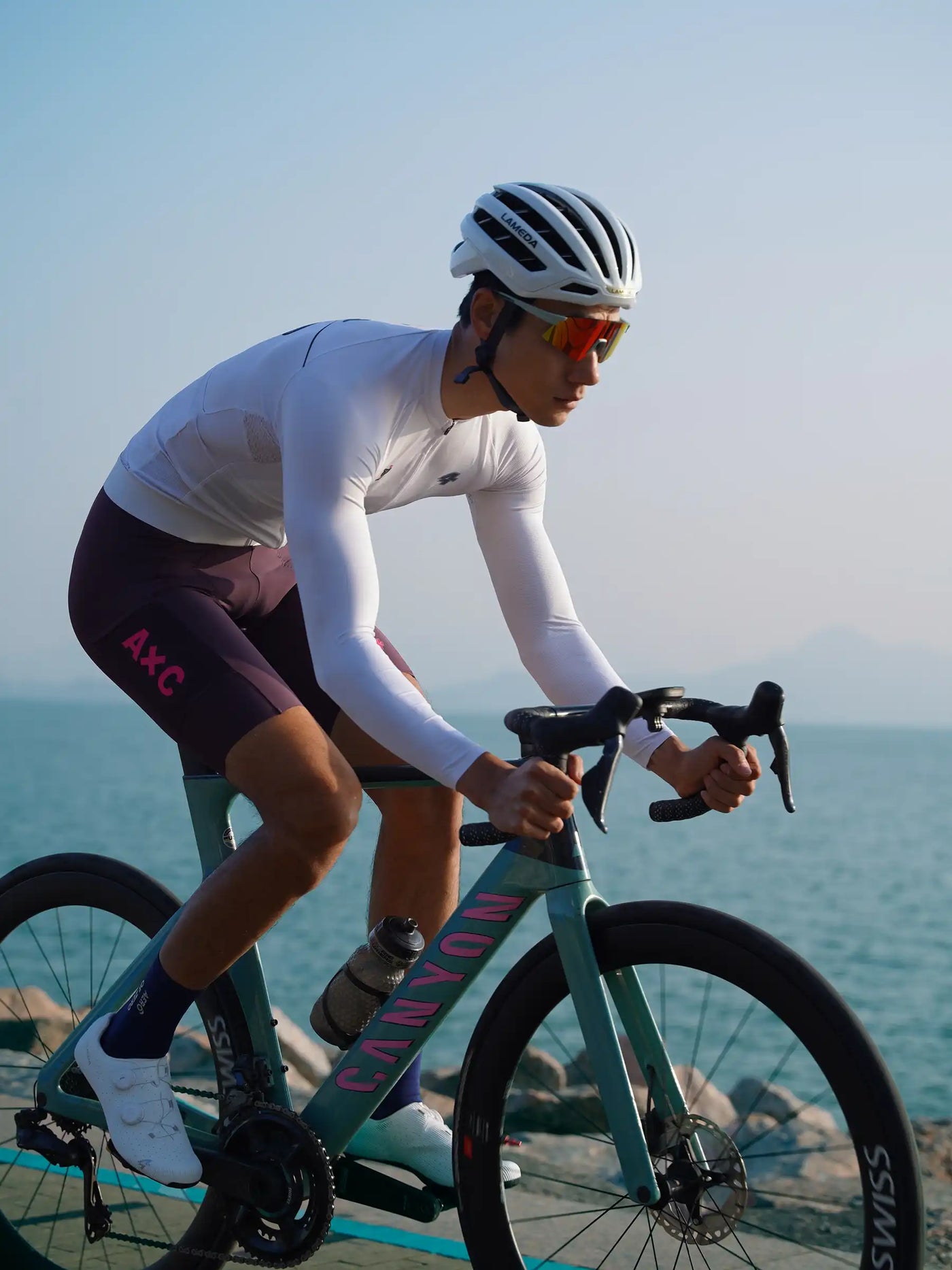 Heart feather herr korta cykelhängselbyxor lila tillsammans med blågrön Canyon vägcykel med rosa varumärkning och svarta styren