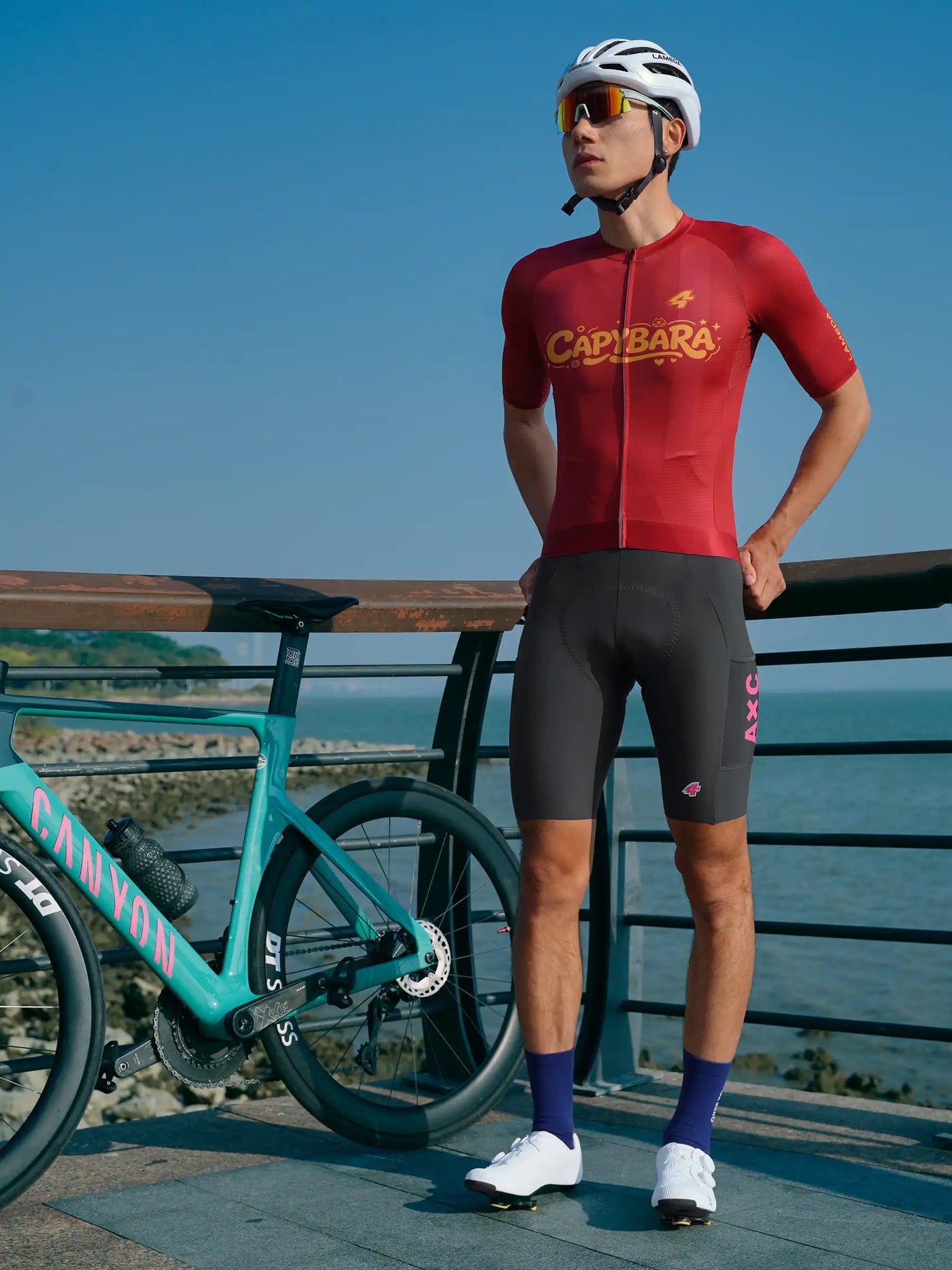 Heart feather herr mörkgrå cykelhängselbyxor med röd canyon cykeltröja med guldtext och logotyp med siffran fyra bakifrån sett