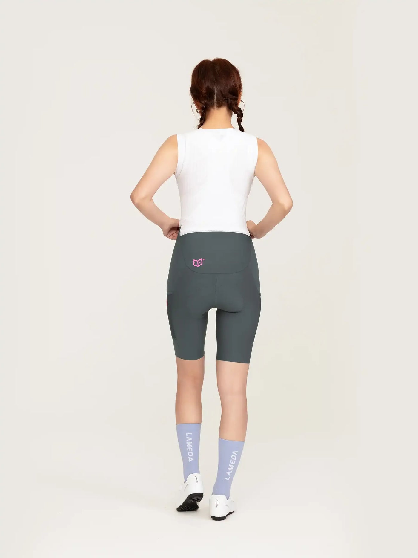 Baksida på heart feather kvinnors bibshorts i mörkgrå med rosa logo på midjebånd för idrottsbruk