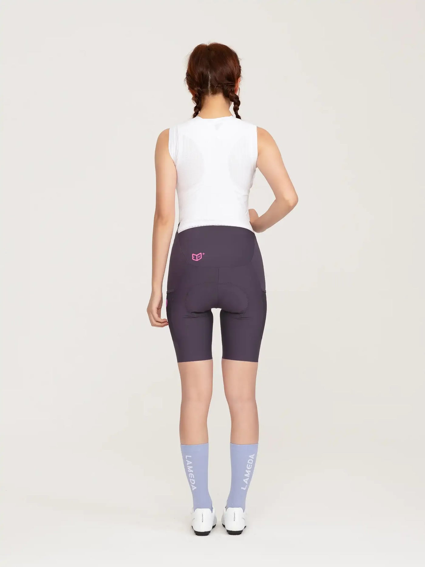Baksida av mörkgrå heart feather damcykelhängbyxor med rosa logo på midjeband i lila design
