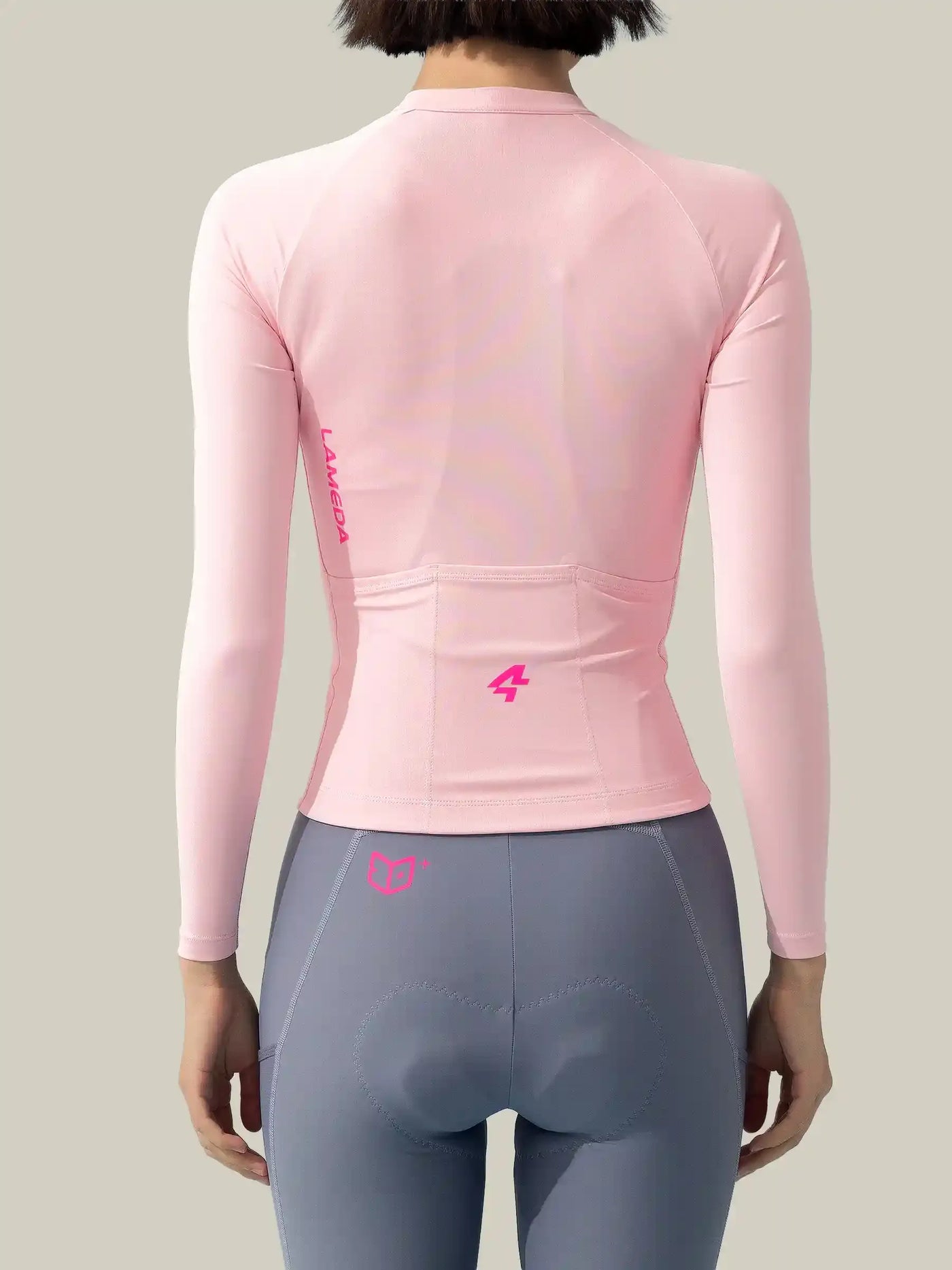 Baksida av långärmad damcykeltröja Wind Chaser i rosa med finstrukturerat tyg och rosa märkning