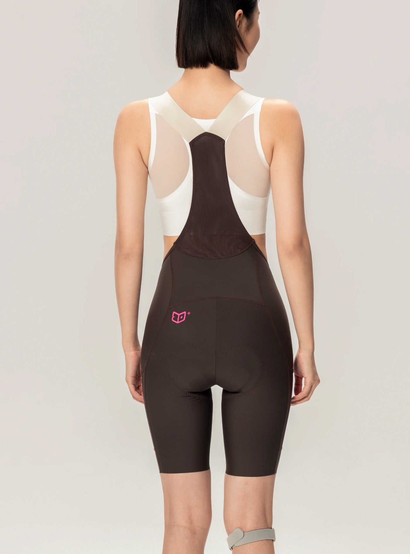 Brun LAMEDA 21:a årsjubileums special damcykelbibshorts med vit nätbakpanel och rosa logo på elastisk skarv på nedre vänstra höften