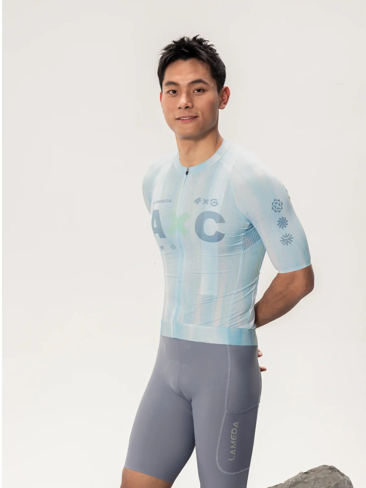 Ljusblå kortärmad unisex cykeltröja LAMEDA x australian studio med subtilt mönster parad med grå shorts