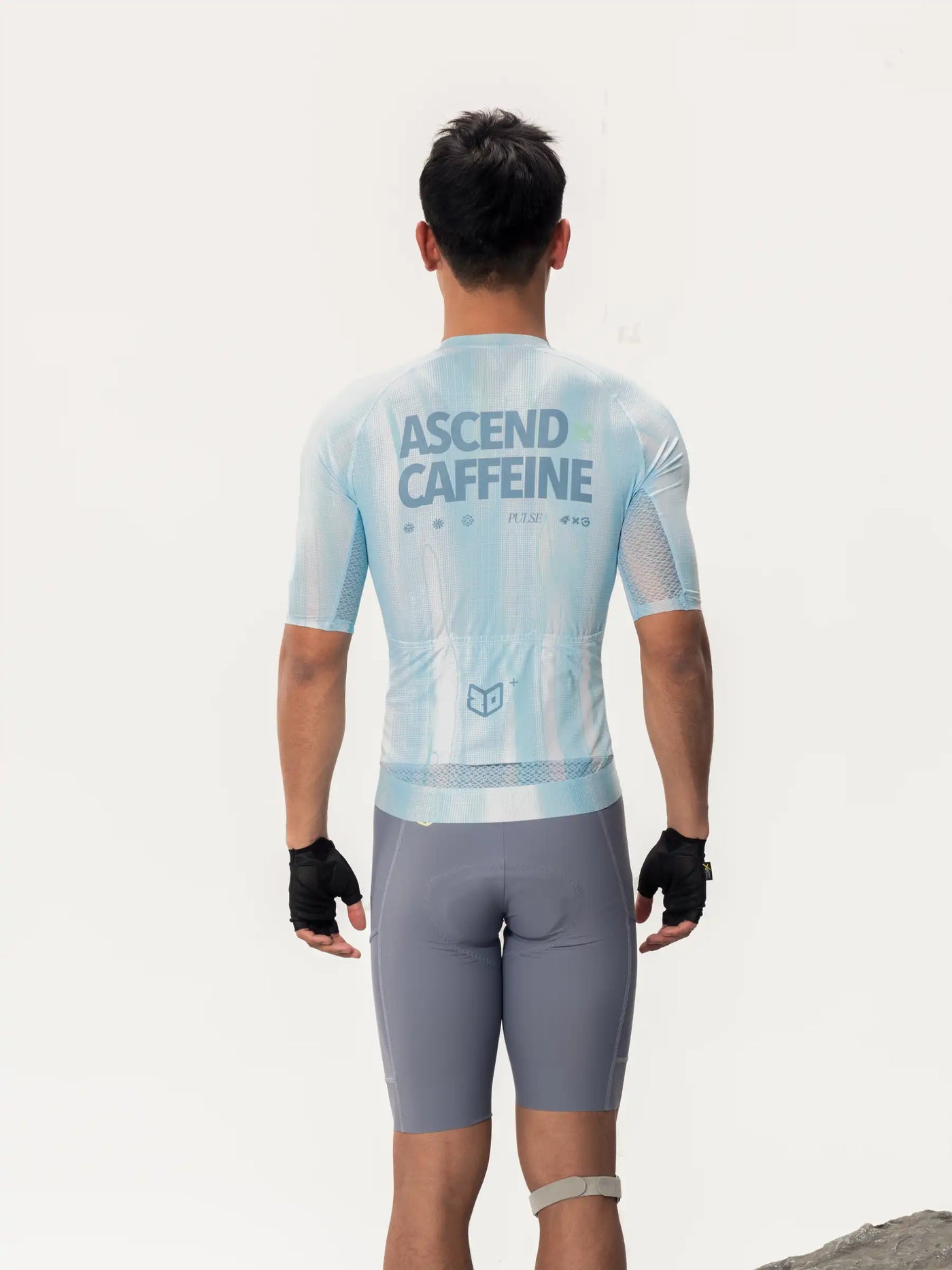 Ljusblå kortärmad LAMEDA x australian studio unisex cykeltröja visad från baksida med ascend caffeine print