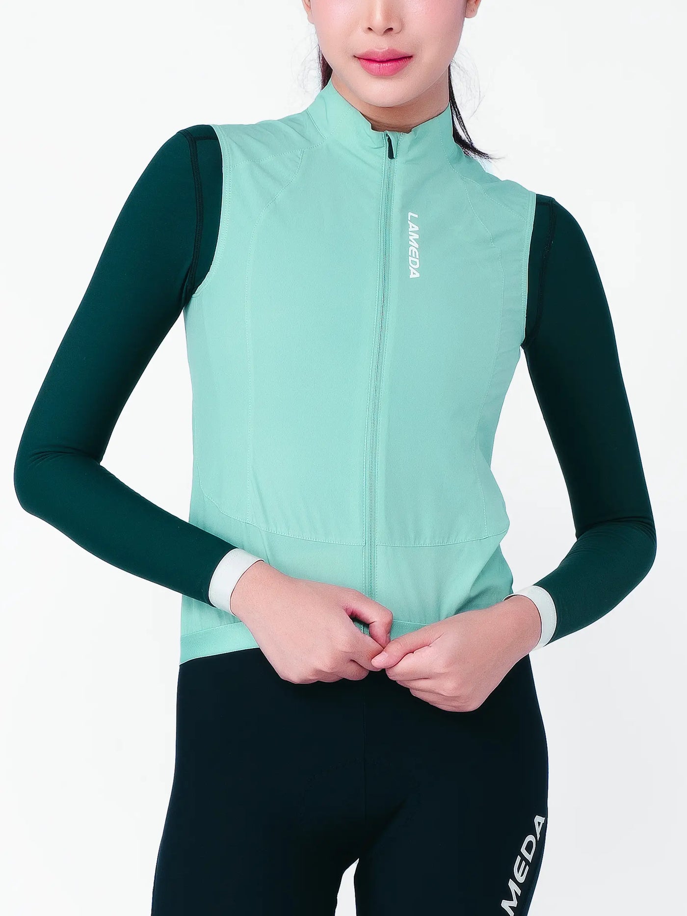 Nova vindtät damcyklingväst i mint och mörkgrön med vit dragkedja tillverkad av återvunnen polyester sorona t800 garn