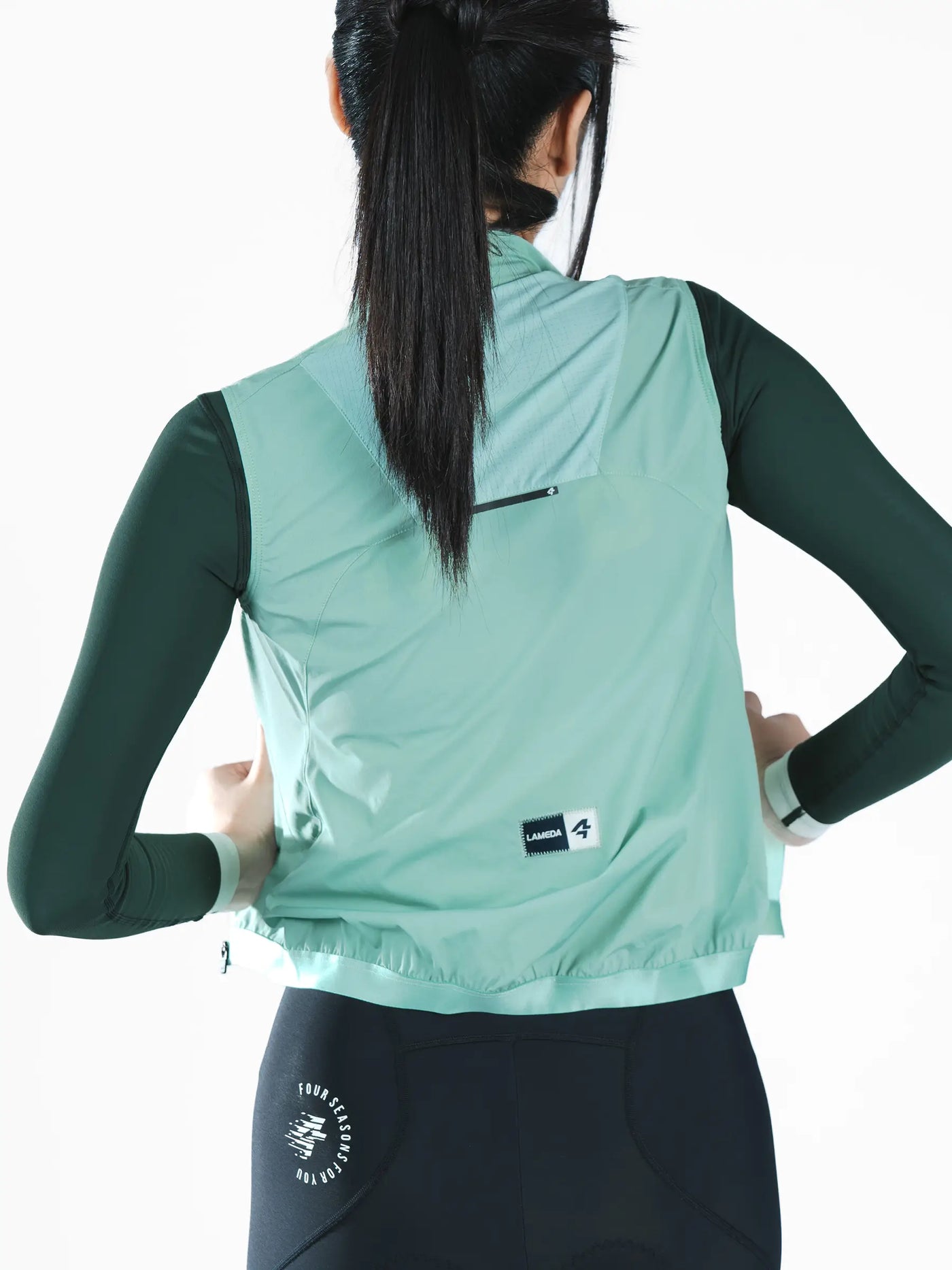 Nova kvinnors vindtäta cykelväst i mintgrön lätt återvunnen polyester med svart dragkedja och varumärkesetikett på baksidan