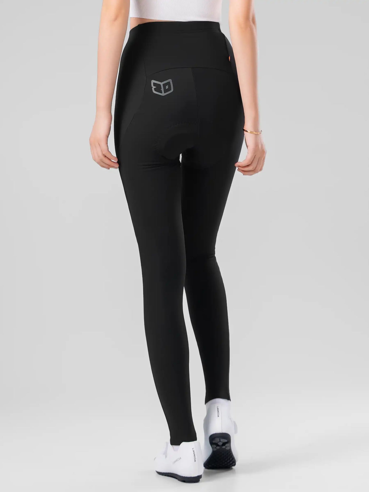 Bakifrån sett på svarta LAMEDA damcykeltights med elastic interface och diskret grå logo på fickan