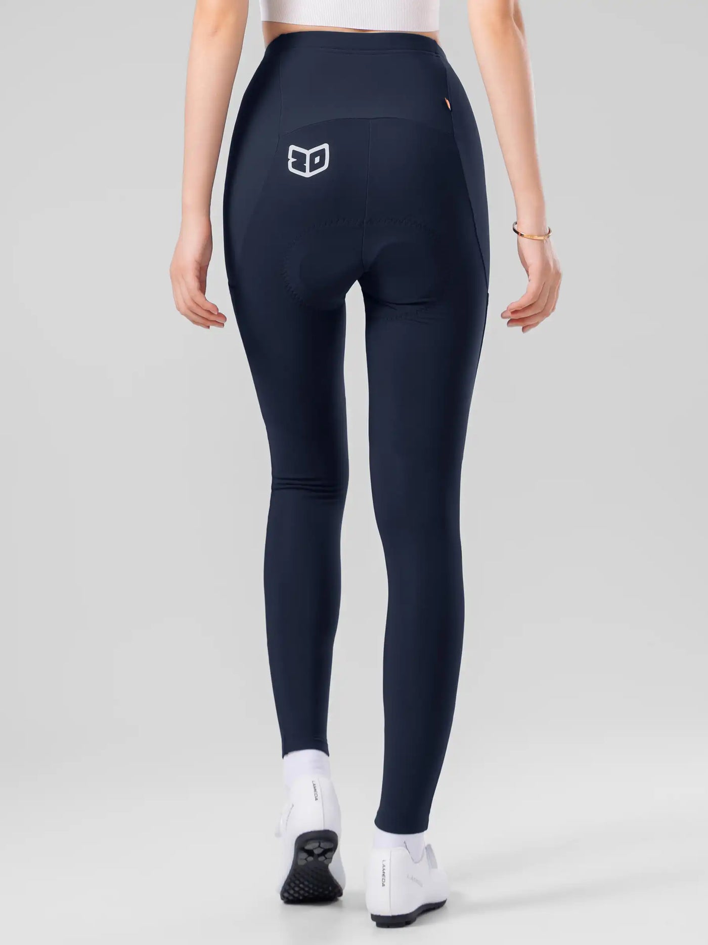 Bakvy av marinblå LAMEDA speciella termo-damcykeltights med elastic interface® och vit logotyp på höften