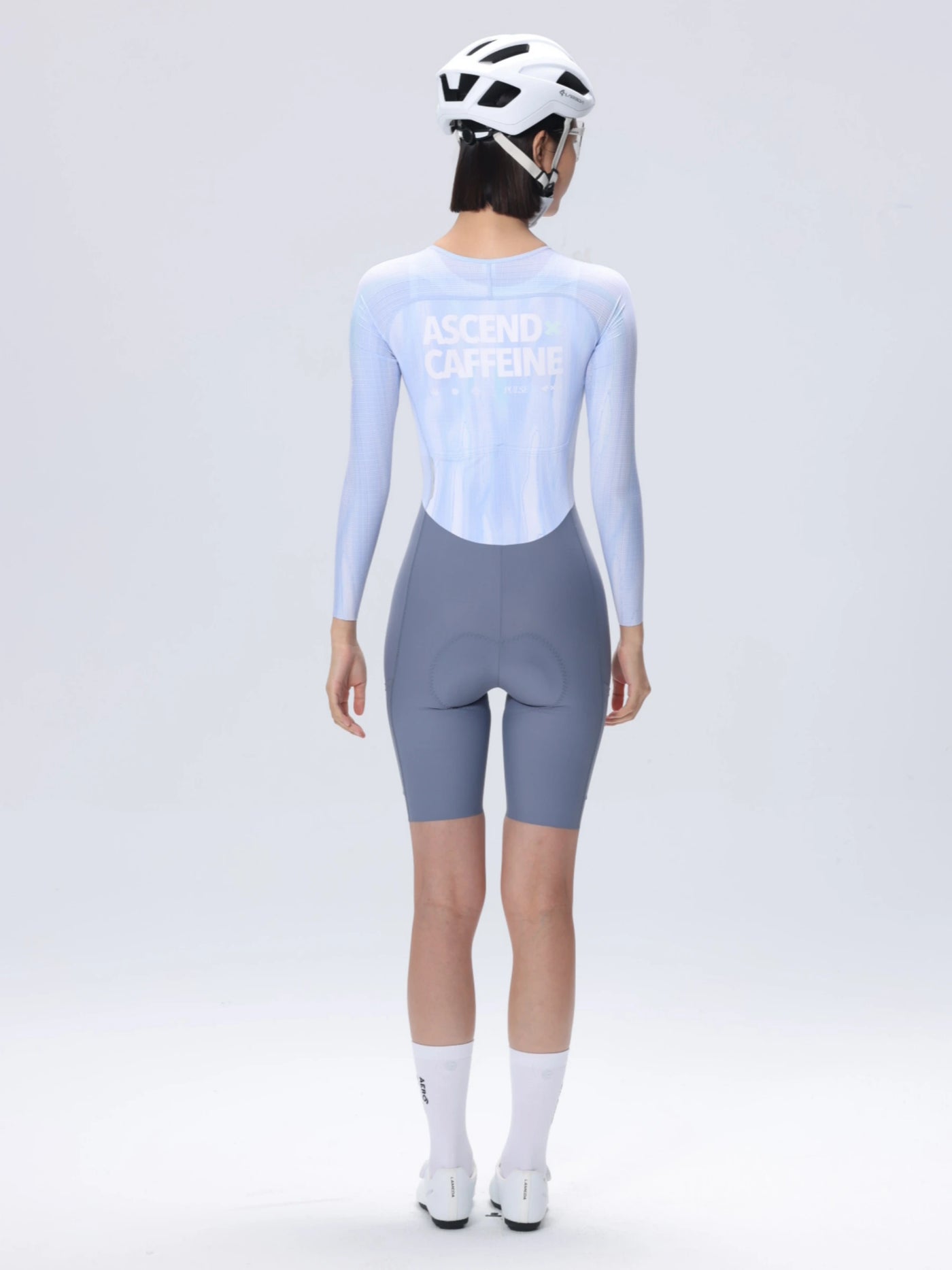 Baksida av LAMEDA ac dam skinsuit med långa ärmar i ljusblått och grått med ascend caffeine print för cykling