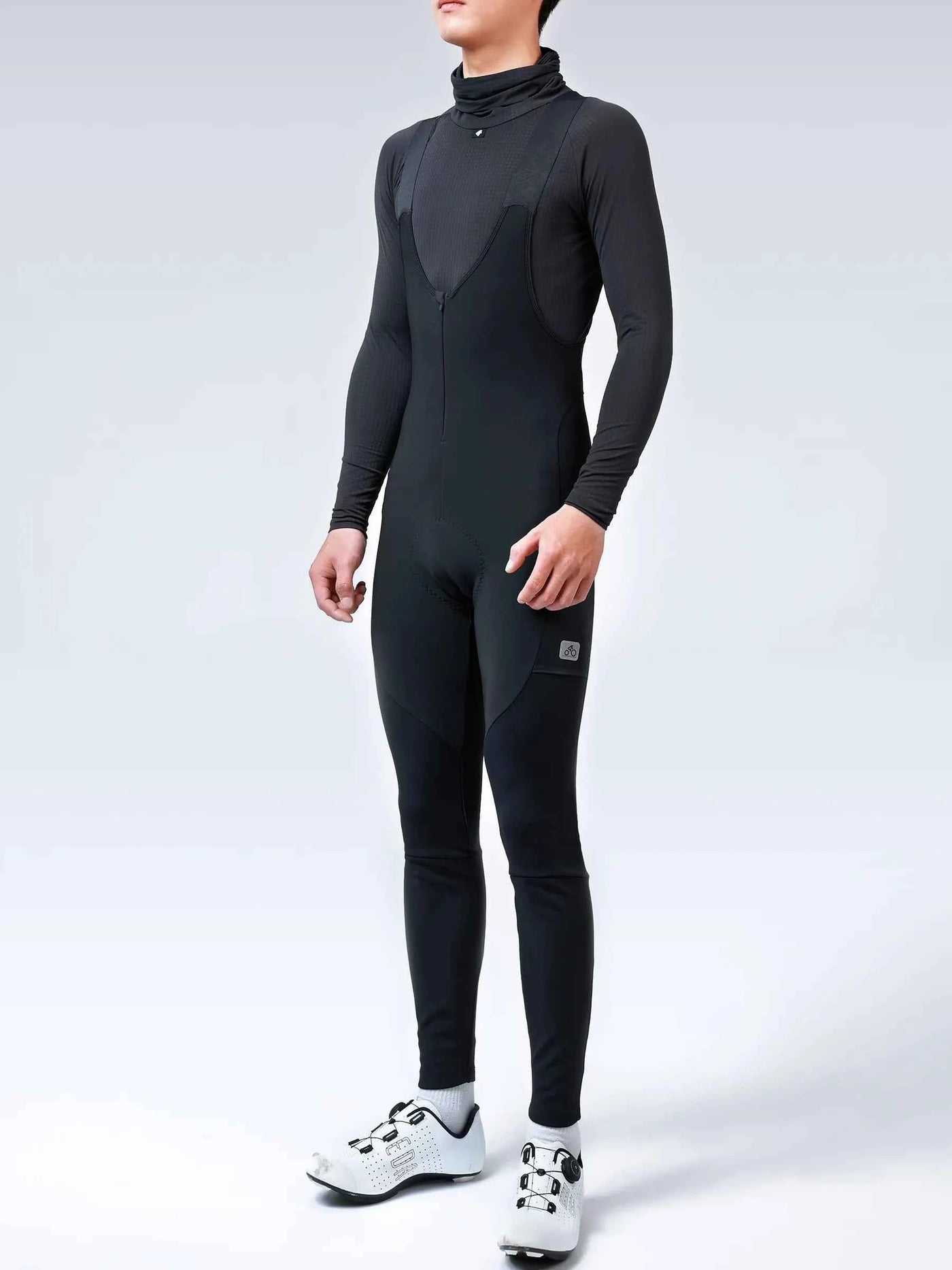 Spear men’s thermal bib tights in black feature a form-fitting design with high collar and subtle paneling details