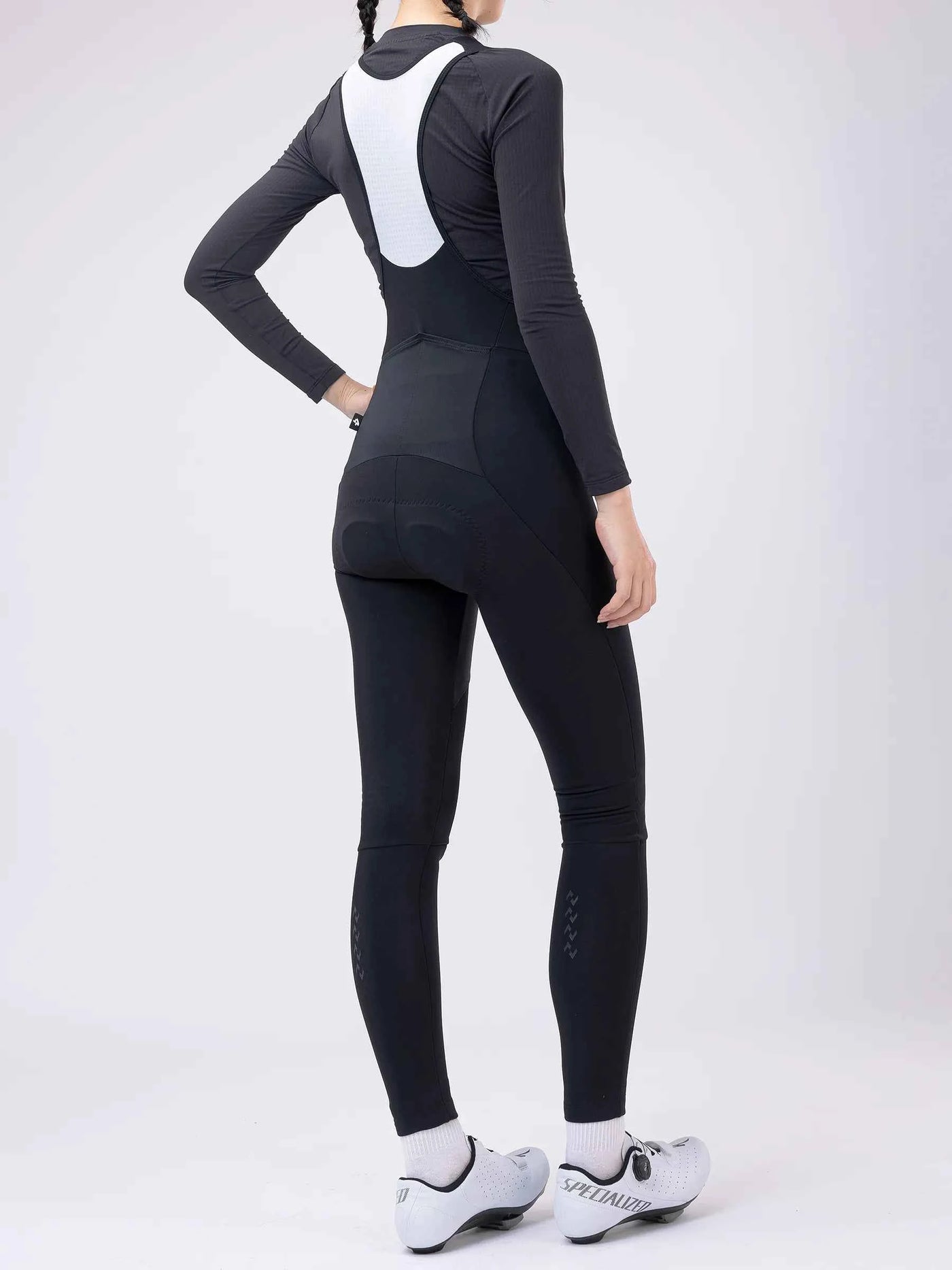 Svartvita långärmade termo-hängselcykeltights med polstrad bakpanel, sömlös design och varumärkeslogotyp på underbenet