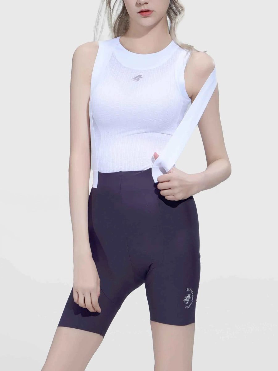 Biała bezrękawna koszulka sportowa z dyskretnym logo w połączeniu z damskimi rowerowymi spodenkami z szelkami LAMEDA Luminance w kolorze fioletu łąkowego z tylną kieszenią