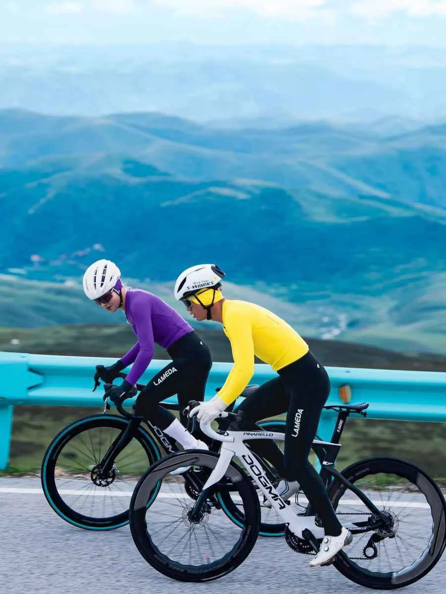 Två cyklister bär lila termiska öronskydd tillverkade av andningsbart tyg med solglasögonvänlig design på bergspass