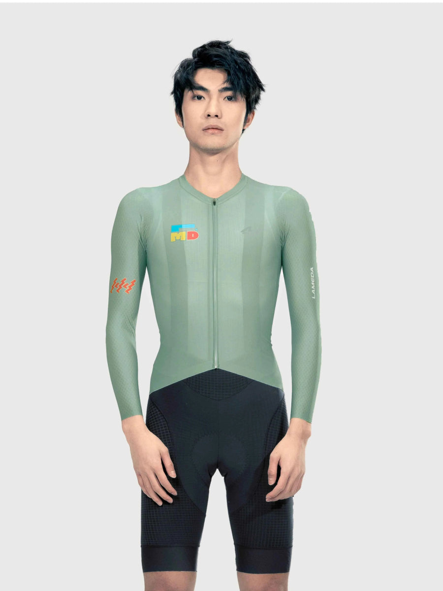 LAMEDA sparkle herrars långärmad cykeltröja i dämpad salviagrön kombinerad med svarta shorts för prestandaanvändning