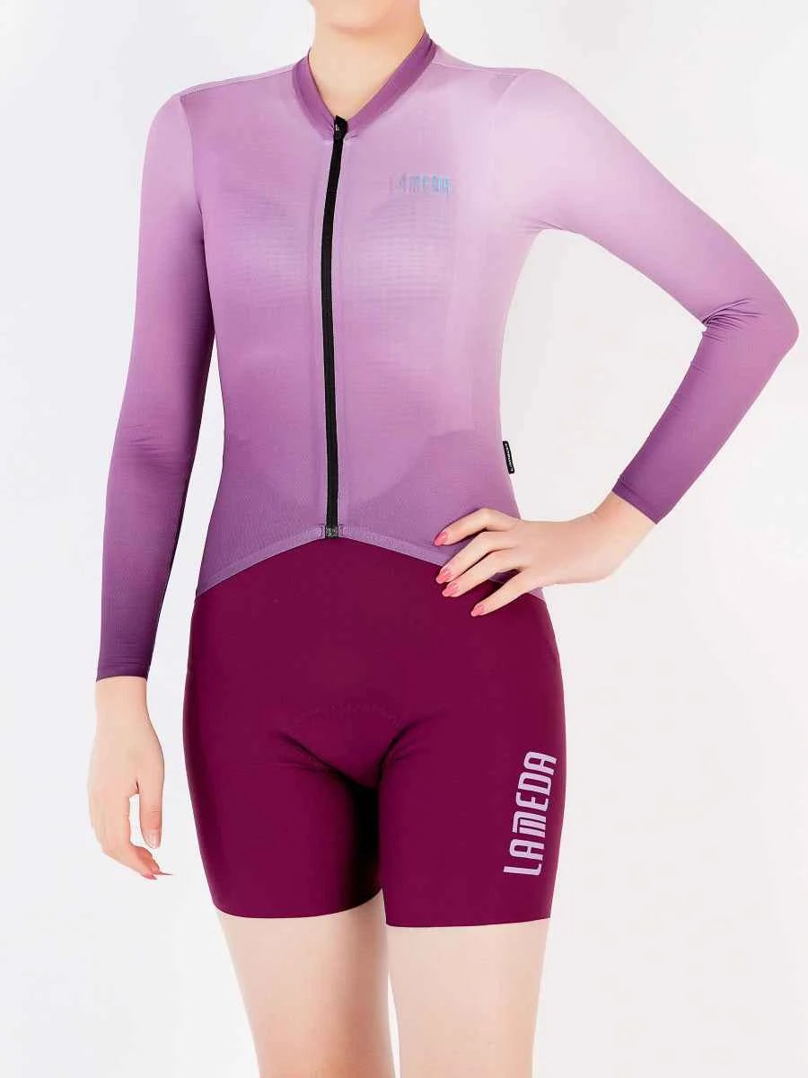 Praktfull damcykeltröja i lila gradient med YKK-blixtlås och matchande rödbruna cykelshorts med iriserande LAMEDA-logo