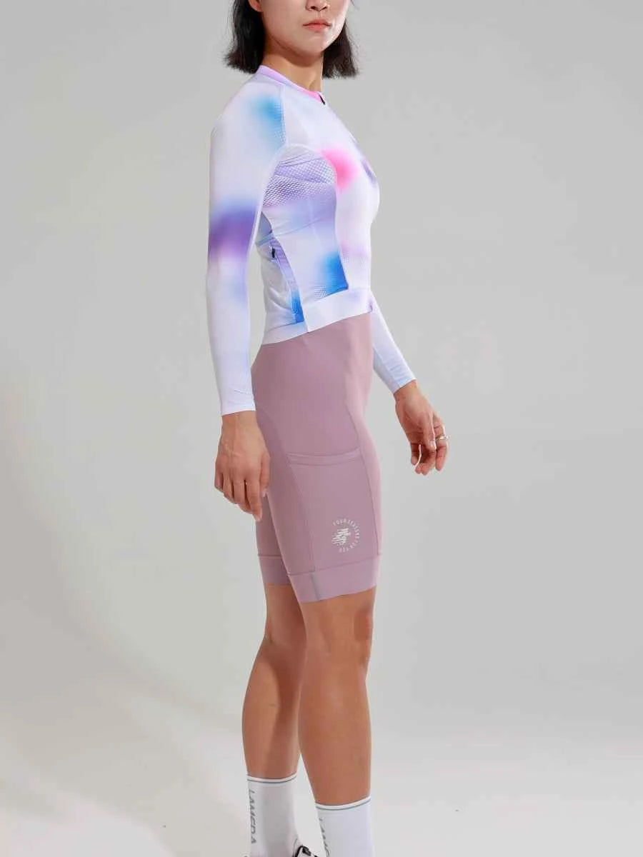 En kvinna som bär damernas elitcykeltröja 2025SSZ589 i rosa med bakficka med dragkedja och matchande mauve shorts